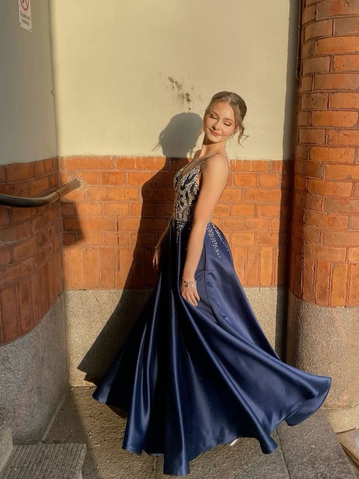 Robe de bal longue sans manches, coupe trapèze, col en V, bleu marine foncé, satin, perles argentées, sequins. Inspiration robe de bal AB1029