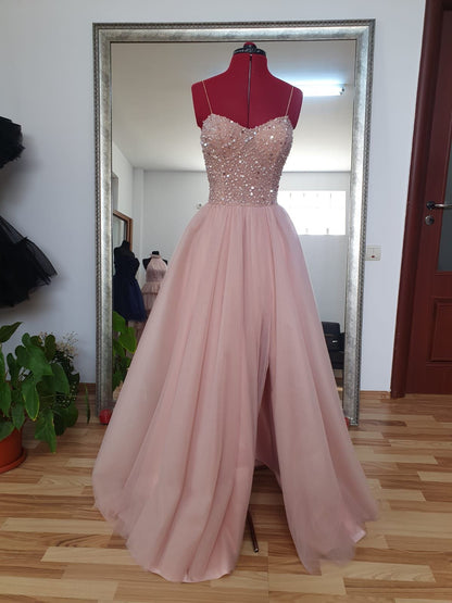Robe de bal unique en tulle rose à fines bretelles et fente, ornée de perles, idéale pour les adolescentes. Tenue de soirée élégante. Modèle N037.