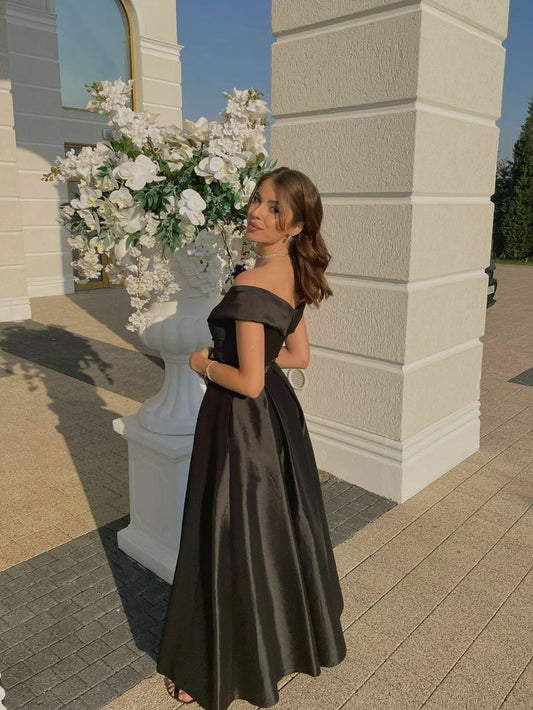 Robe de soirée noire longue, élégante et fendue, coupe trapèze, épaules dénudées, style classique, idéale pour les bals de fin d'année et les dîners. Modèle AB2097.