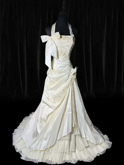 Zeitlose lange Brautkleider im Stil der 70er Jahre: Elegante Neckholderkleider im Meerjungfrauen- und Boho-Stil mit Spitze, figurbetont und perlenbesetzt – auch in kleinen und großen Größen erhältlich (AS050).