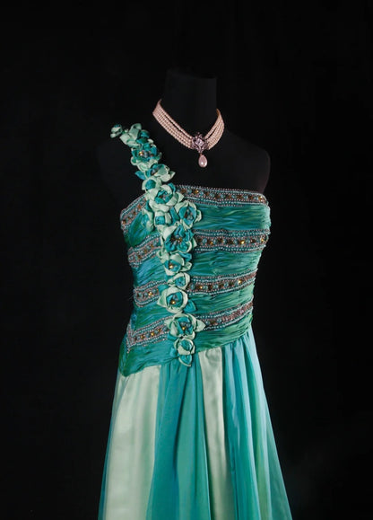 Robe de bal longue sans manches, coupe trapèze, style rétro années 60/70, multicolore (vert et bleu), ornée de perles et de pierres précieuses. Référence AS147.
