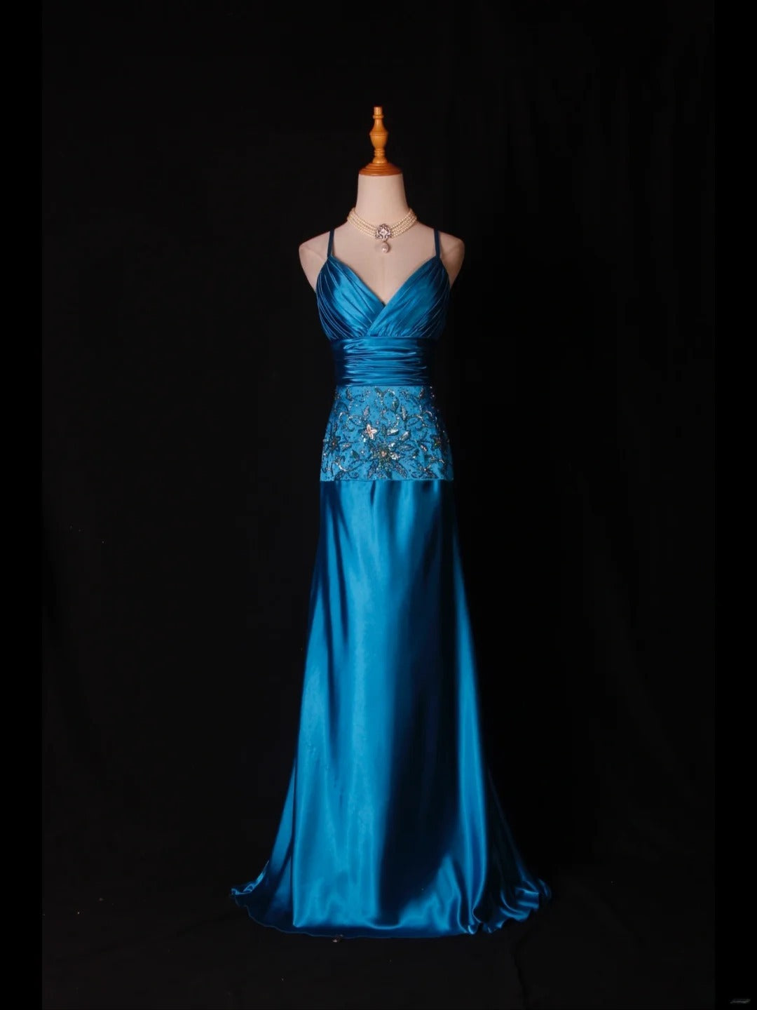 Robe de bal longue vintage en satin bleu à fines bretelles et sequins, coupe trapèze, ornée de perles et d'un corsage perlé. Idéale pour un 18e anniversaire. Référence AS282.