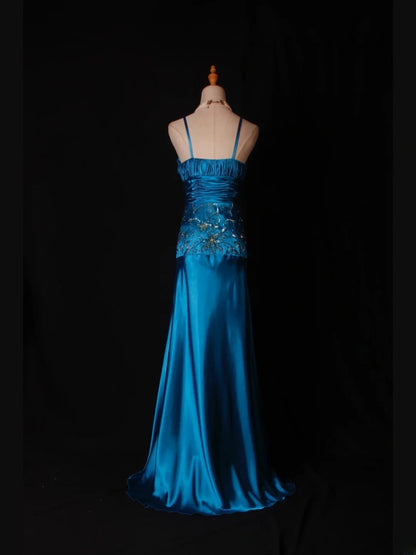 Robe de bal longue vintage en satin bleu à fines bretelles et sequins, coupe trapèze, ornée de perles et d'un corsage perlé. Idéale pour un 18e anniversaire. Référence AS282.