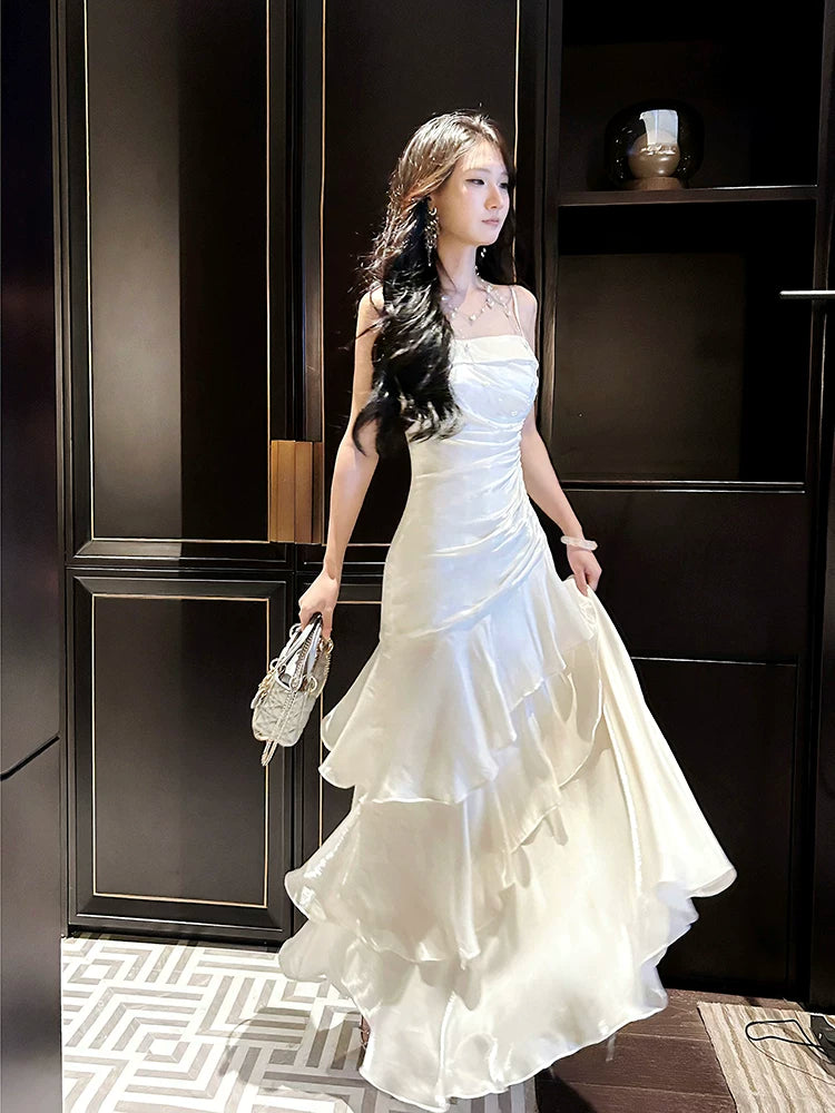 Robe de bal longue blanche à fines bretelles spaghetti et volants, style sirène, idéale pour les lycéennes, les jeunes filles et les jeunes filles. Parfaite pour une soirée de fin d'année ou un anniversaire (20 ans). Référence : AB2503